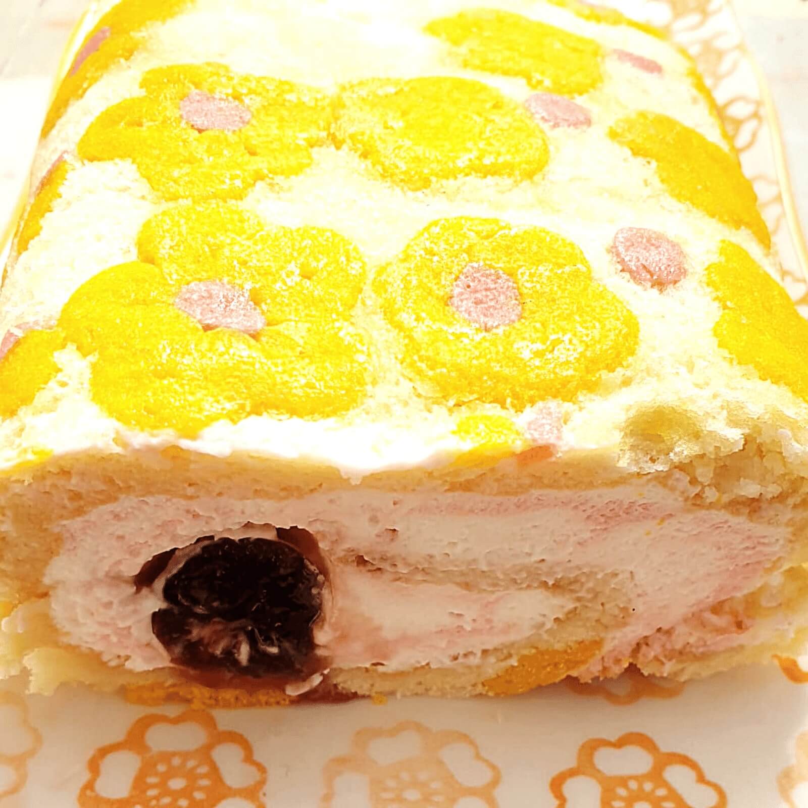 עוגת רולדת גבינה ללא גלוטן מקושטת לשבועות פרחים צהובים